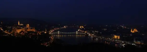 Panoramic view from the top of Gellért Hill in Budapest. The chain bridge illuminated over the Danube river.