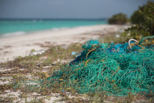 Discarded fishing 'Ghost Net' on beach Net found on Maldives island  Beach; which is harmful to marine and coastal life commercial fishing net stock pictures, royalty-free photos & images