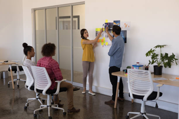 istock Diverse business partners presenting to colleagues in a bright modern office 1133831774
