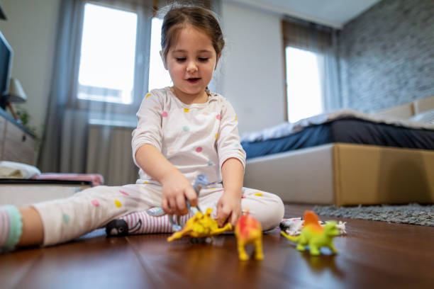 Top view of happy girl playing a board game jenga with her parents sitting on the floor on a rug in the living room, sharing moments and having fun together on a weekend, physically disabled girl, amputee.