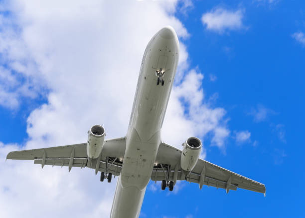 istock Flapping plane on a background of blue sky and white clouds.  Airliner. Bottom view. 1133834148