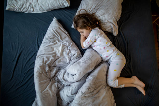 Lovely sleeping child in bed stock photo