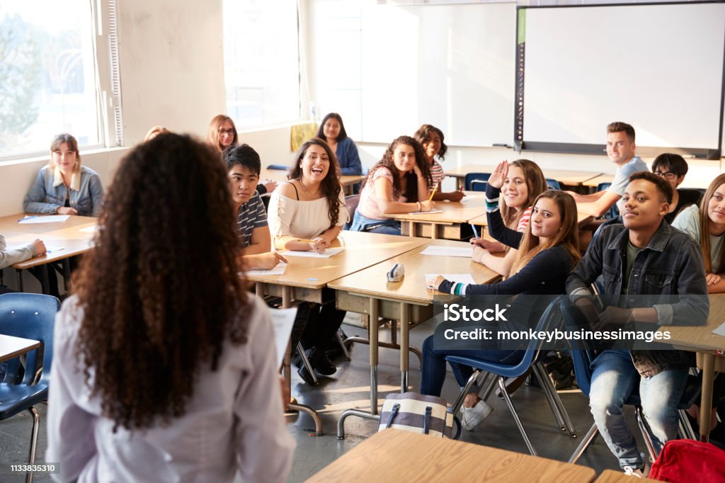 Vue arrière de l'enseignant de lycée féminin restant devant la leçon d'enseignement de classe - Photo de Salle de classe libre de droits