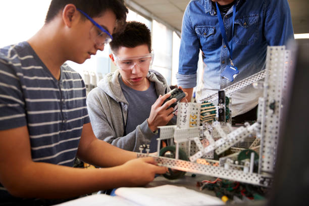 istock Teacher With Two Male College Students Building Machine In Science Robotics Or Engineering Class 1133836173
