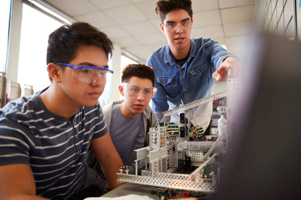 istock Teacher With Two Male College Students Building Machine In Science Robotics Or Engineering Class 1133836175