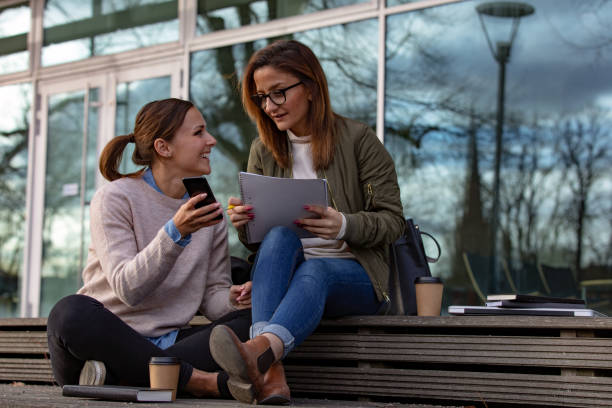 istock Two female students looking at phone 1133836432