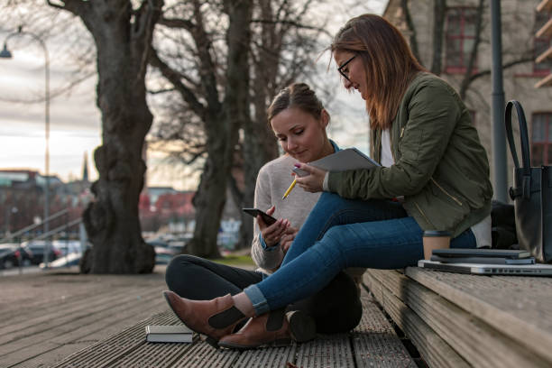 Two female students looking at phone
