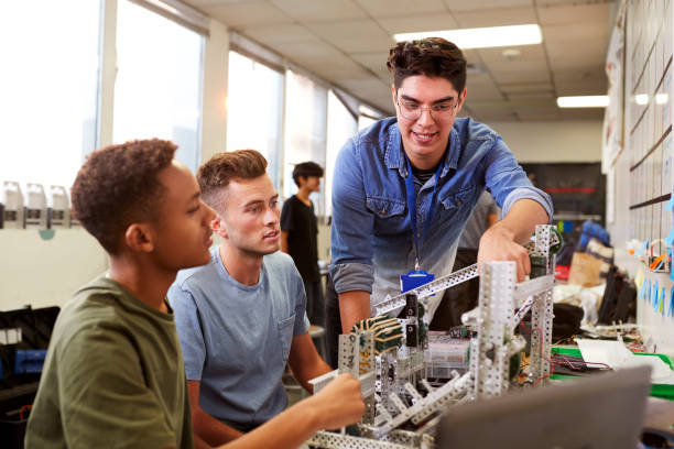 istock Teacher With Two Male University Students Building Machine In Science Robotics Or Engineering Class 1133836480