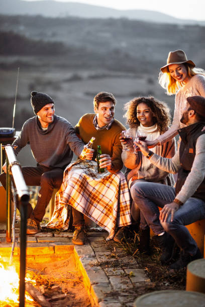 istock Young happy friends enjoying in alcohol by the fire. 1133843548