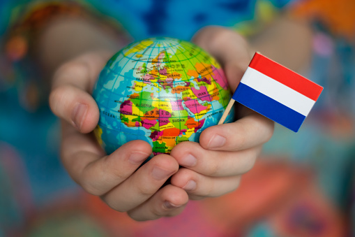 Globe in hands with the flag of the Netherlands