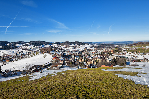 Herisau is the capital city of the canton Appenzell Ausserrhoden in Switzerland. Panoramic view over landscape and cityscape in springtime with some snow on the hills