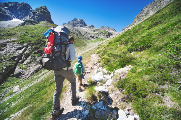 istock Father and son hiking together in mountains 1133853039