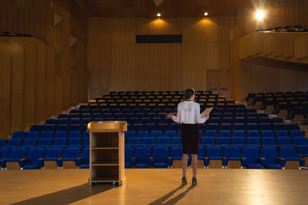 businesswoman practicing and learning script while standing in the auditorium - lecture hall auditorium university empty imagens e fotografias de stock