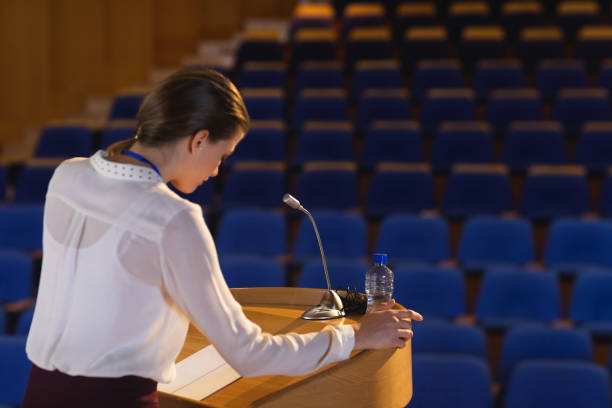 istock Businesswoman looking in script  and trying to speak in the empty auditorium 1133854469