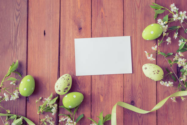 istock Mockup white greeting card and easter eggs with white spring flowers on a wooden background 1133854765