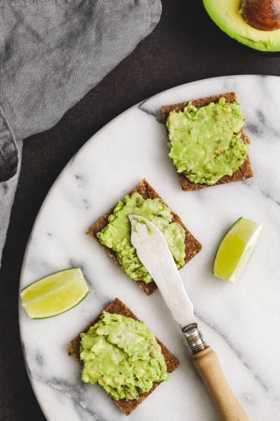 istock Three snacks with rye bread and mashed avocado on a white marble tray. The concept of healthy fast snack. 1133855082