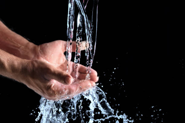 istock fresh water splashes into human hands against a black background, concept for the protection of water resources, copy space, selected focus 1133855279