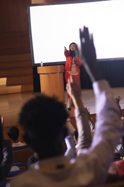 istock Audience raising hand for the queries in the auditorium 1133855357