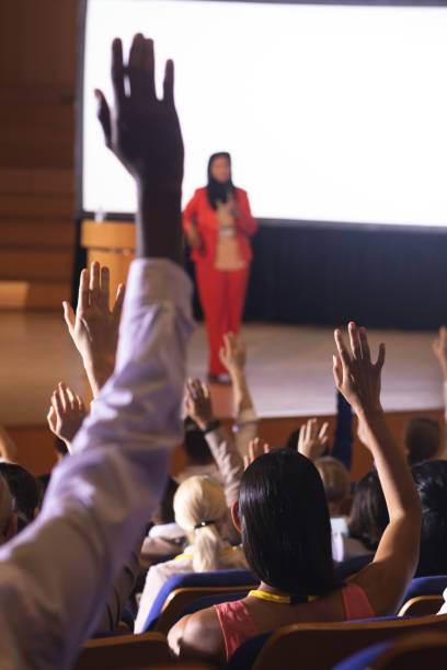 istock Audience raising hand for asking question in the auditorium 1133855922