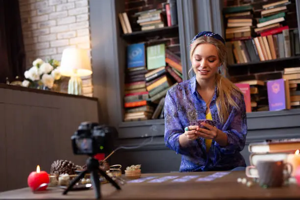 Photo of Positive joyful young woman reading tarot cards