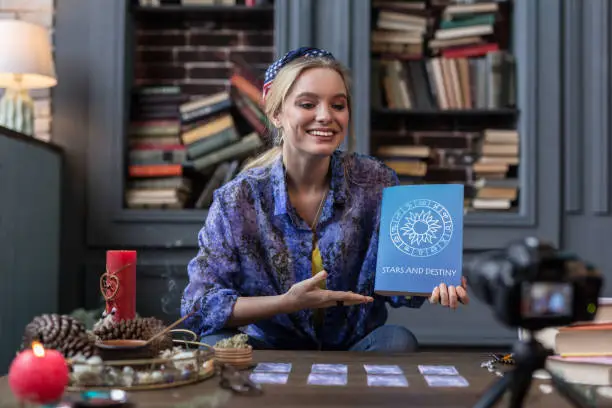 Photo of Nice cheerful woman pointing at the book