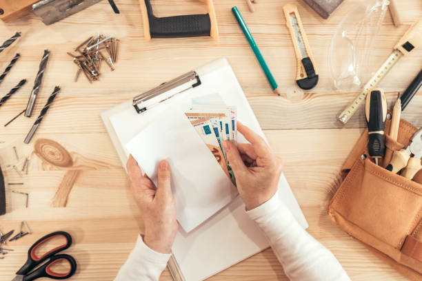 istock Female carpenter counting money, top view 1133859351