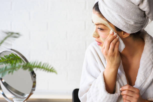 istock Young woman applying face mask at home 1133860165