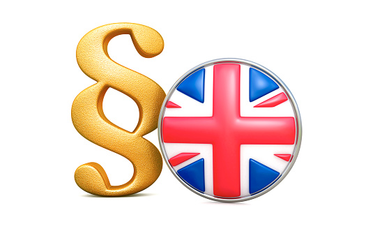 Golden paragraph sign with round flag of the UK, 3d render