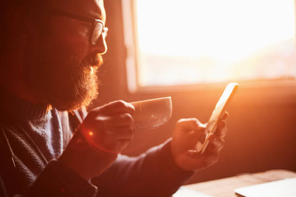 istock young man watching movie on coffee phone in hand 1133868530