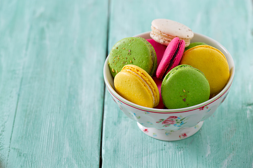 macaroons in a bowl on wooden surface