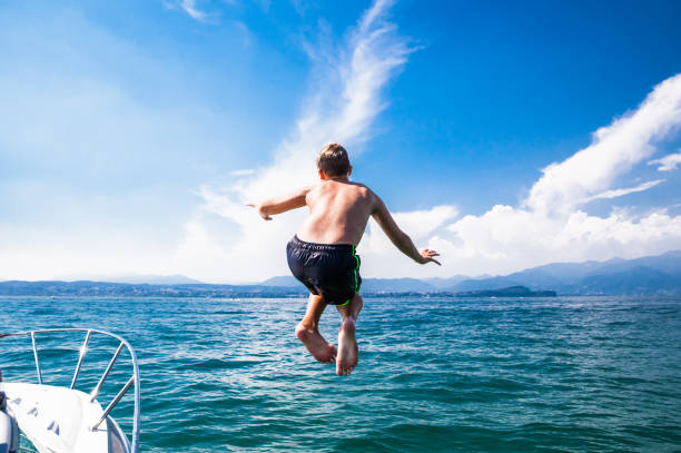 chico adolescente saltando a un lago - child jumping swimming nautical vessel fotografías e imágenes de stock