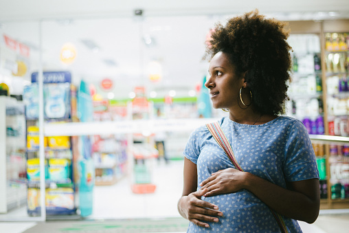 Pregnant woman in front of pharmacy