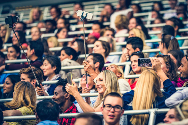 istock People on a stadium taking selfies with selfie sticks 1133871918