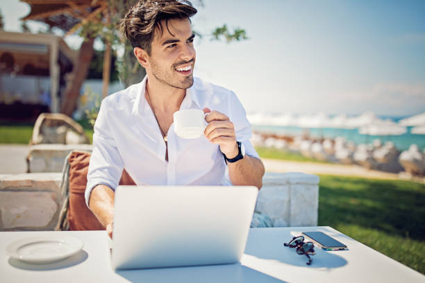istock Young businessman is working and drinking coffee on the beach 1133872066