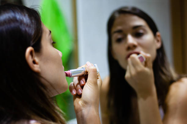 istock Girl applying lipstick in the mirror 1133873317