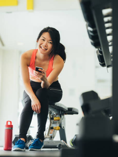 istock Young Asian woman using phone in gym 1133873424