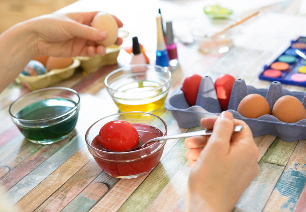 Woman paints colorfull Easter eggs. Family preparing for EasterWoman paints colorfull Easter eggs. Family preparing for EasterWoman paints colorfull Easter eggs. Family preparing for Easter