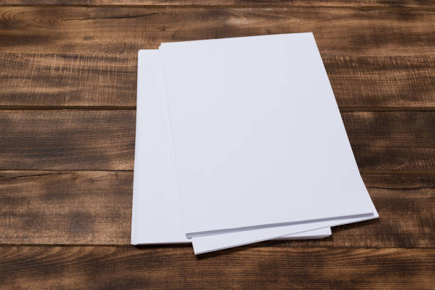 istock Blank paper notebook on brown wooden table background. Top view with copy space 1133877332