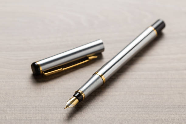 istock fountain pen on wooden table 1133877478