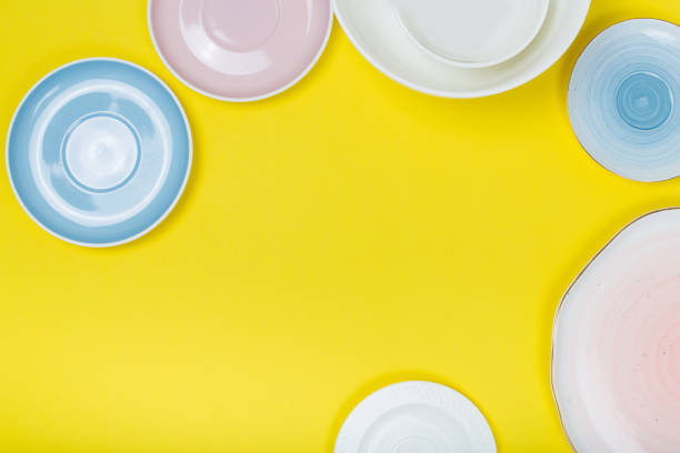 istock kitchen utensils, Clean  porcelain dishes on yellow  background. Top view 1133877538