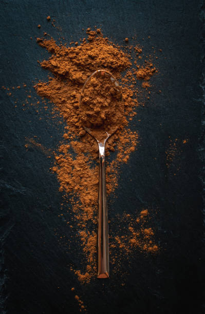 istock Ground cinnamon in teaspoon on dark background, top view, text space 1133877976