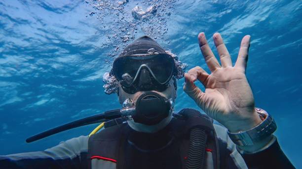 Man scuba diver underwater showing signal OK Man scuba diver underwater showing signal OK. Descending. deep sea diving underwater underwater diving scuba diving stock pictures, royalty-free photos & images