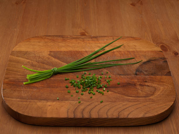 Garlic chives isolated on wooden background