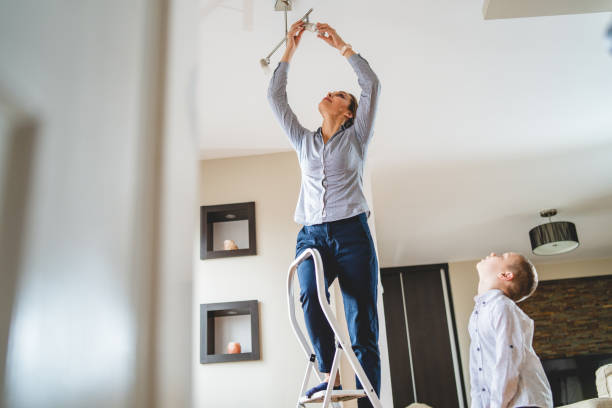 istock Little boy helping mother to change a lightbulb 1133884953