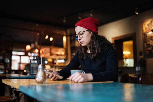 istock Woman using smartphone in coffee shop 1133885210