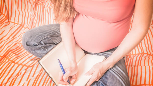 istock Pregnant woman is handwriting a birth plan at home 1133885405