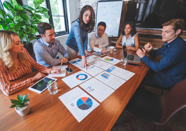 istock Paperwork and hands on a board room table at a business presentation or seminar. 1133887503