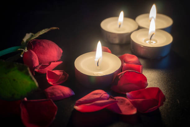 istock Four tea candles and rose petals in the dark 1133887835