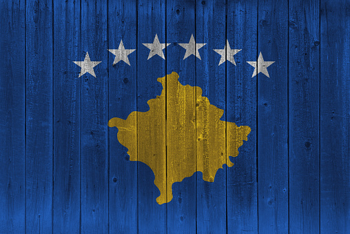 Kosovo flag painted on old wood plank. Patriotic background. National flag of Kosovo