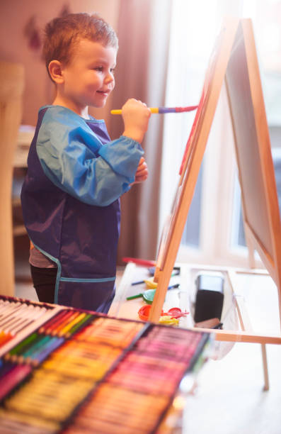 istock Smiling toddler painting at home 1133892217